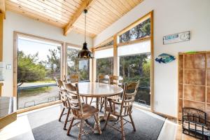 a dining room with a table and chairs and windows at Casa Contenta in Gualala