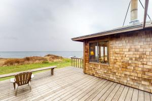 a wooden deck with a bench and a building at Comstock Retreat in Sea Ranch