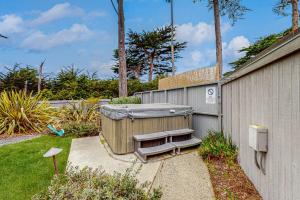 a backyard with a hot tub next to a fence at Brammer's Bluff in Sea Ranch