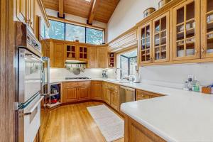 a kitchen with wooden cabinets and a white refrigerator at Brammer's Bluff in Sea Ranch