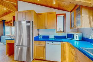 a kitchen with a stainless steel refrigerator and wooden cabinets at Gewing House in Sea Ranch