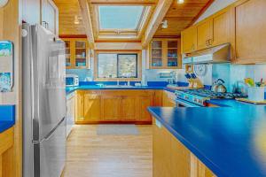 a kitchen with a blue counter top and a refrigerator at Gewing House in Sea Ranch +20 photos