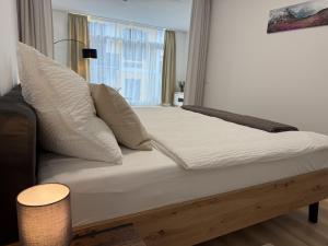 a bed with white sheets and pillows in a room at GMA Studio Apartment im Zentrum in Bad Ischl