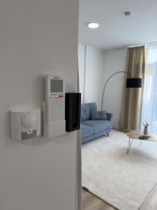 a living room with a blue couch and a machine on the wall at GMA Studio Apartment im Zentrum in Bad Ischl