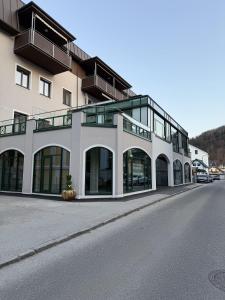 a large building with glass windows on a street at GMA Studio Apartment im Zentrum in Bad Ischl