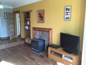 a living room with a fireplace and a tv at The Manor House, Killearn in Killearn