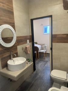 a bathroom with a sink and a toilet and a mirror at Aqui es 6! in Banfield +6 photos