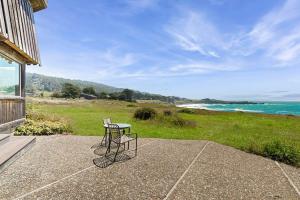 a table and chair sitting on a patio near the ocean at Curtis-Moulton Retreat in Sea Ranch