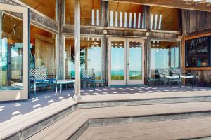 a porch with chairs and tables and windows at Curtis-Moulton Retreat in Sea Ranch