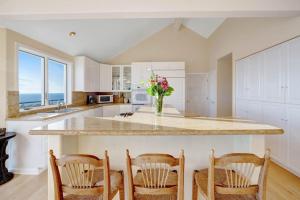 a kitchen with a counter with chairs and a vase of flowers at The Cliff House in Gualala