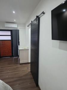 a room with a black closet with a television on a wall at 47 Northward BnB in Newcastle