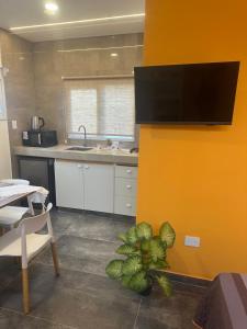 a kitchen with a yellow wall with a tv on it at Aqui es 6! in Banfield