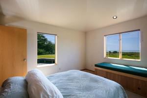 a bedroom with a bed and two windows at Toto House in Gualala