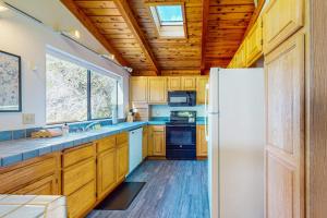 a kitchen with wooden cabinets and a white refrigerator at The Bobcat House in Sea Ranch