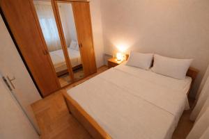 a small bedroom with a bed and a mirror at Studio Centar in Trebinje +5 photos