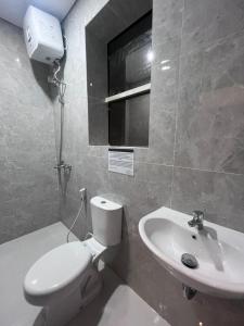 a bathroom with a toilet and a sink at The Haven Suites Batam in Tanjunguma