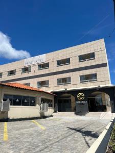 a hotel with a parking lot in front of it at Hotel Prime Ceaka in Caruaru