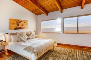 a bedroom with a bed and two windows at Casa Pelo Mar in Sea Ranch