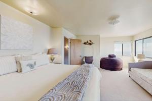 a bedroom with a large white bed and a couch at The Lookout Point in Gualala