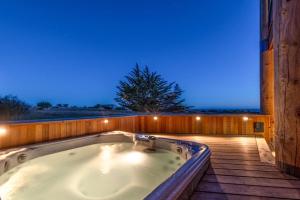 a jacuzzi tub on a deck at night at Seas the Day in Sea Ranch