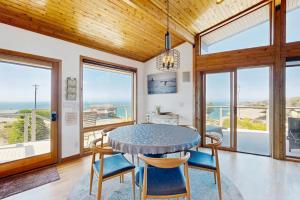 a dining room with a table and chairs and windows at Gualala Harmony House in Gualala +25 photos