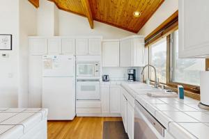a kitchen with white appliances and a wooden ceiling at Gualala Harmony House in Gualala