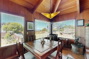 a dining room with a wooden table and a large window at Nature's Paradise in Gualala