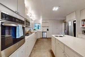 a large kitchen with white cabinets and stainless steel appliances at Tree House in Sea Ranch