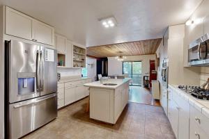 a large kitchen with white cabinets and stainless steel appliances at Tree House in Sea Ranch