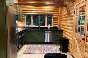 a kitchen with green cabinets and a refrigerator at Cabin Fever in Gualala