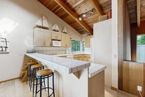 a kitchen with a counter and some stools in it at Sea Trees in Sea Ranch