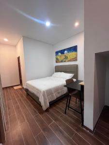 a bedroom with a bed and a desk in it at The Haven Suites Batam in Tanjunguma