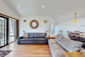 a living room with a couch and a clock on the wall at Footloose in Sea Ranch