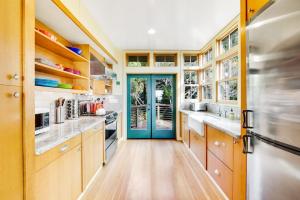 a kitchen with wooden cabinets and a blue door at Shangri-lala in Gualala