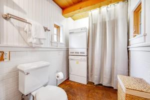 a white bathroom with a toilet and a shower curtain at Shangri-lala in Gualala +28 photos