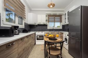 a kitchen with white cabinets and a table with fruits on it at Destinys Village I in Zakynthos