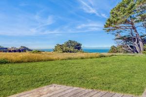 a view of the ocean from a lawn with a wooden deck at Albatross Reach in Sea Ranch