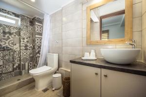 a bathroom with a sink and a toilet and a mirror at Destinys Village I in Zakynthos