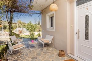 a patio with chairs and a table and a door at Destinys Village I in Zakynthos