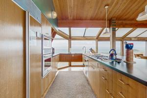 a kitchen with wooden cabinets and a large window at Compass Rose in Sea Ranch