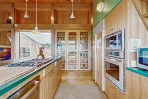 a kitchen with wooden walls and a counter with a stove at Compass Rose in Sea Ranch