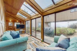 a living room with a blue couch and a tv at Compass Rose in Sea Ranch +26 photos