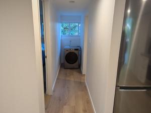 a hallway with a washing machine in a room at Entire Garden Suite in North Vancouver in North Vancouver