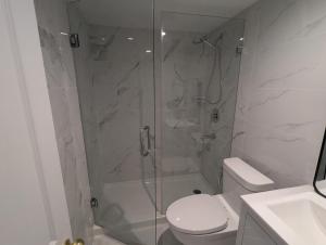 a bathroom with a shower with a toilet and a sink at Entire Garden Suite in North Vancouver in North Vancouver