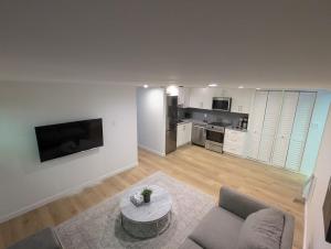 a white living room with a couch and a table at Entire Garden Suite in North Vancouver in North Vancouver