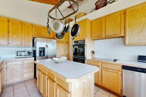 a kitchen with wooden cabinets and a white counter top at Whale Tales in Gualala +19 photos