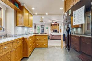 a large kitchen with wooden cabinets and a refrigerator at Spyglass View in Sea Ranch +17 photos
