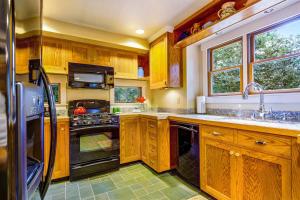 a kitchen with wooden cabinets and a sink and a stove at Spyglass View in Sea Ranch