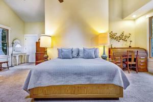 a bedroom with a large bed with blue pillows at Spyglass View in Sea Ranch
