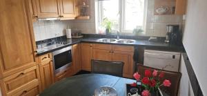 a kitchen with a table and a sink and a table with flowers at Spekenbrink-Haaksbergen in Haaksbergen +17 photos